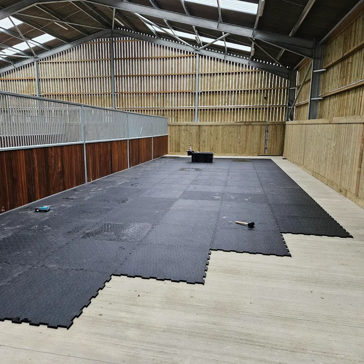 The Belmondo® Basic mats being installed in a crew yard at one of World Horse Welfare's many locations. The Belmondo® Basic mats in the process of being laid in one of World Horse Welfare's locations in the UK.