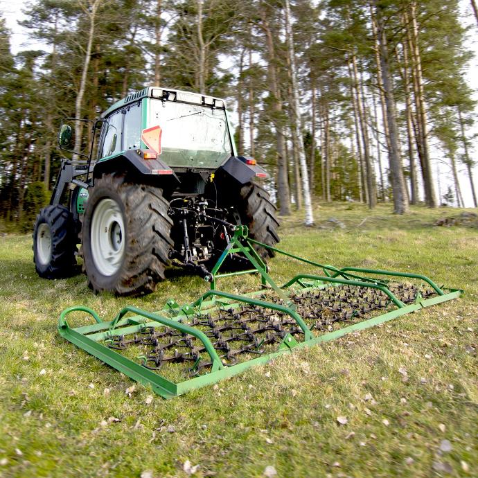 harrowing a paddock with a tractor mounted chain harrow