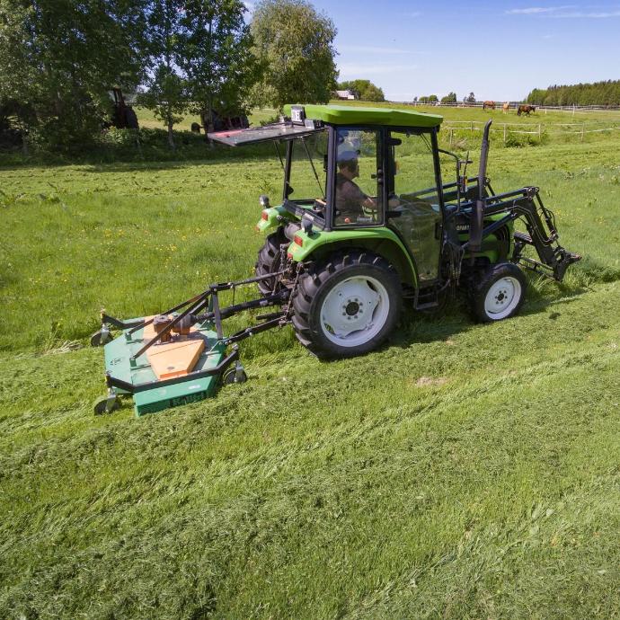 mowing the grassland with a tractor mower